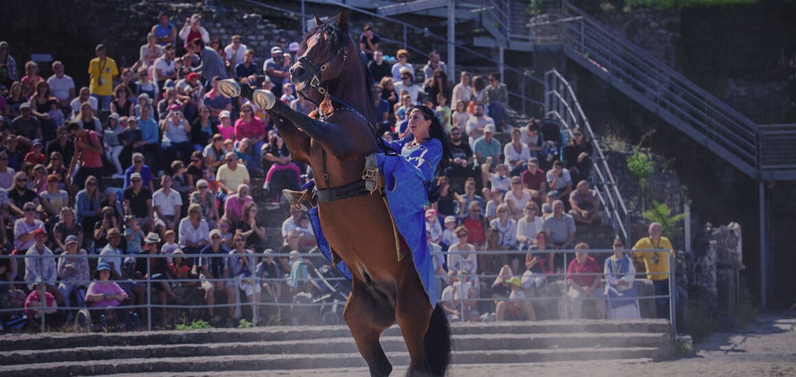 Femme en robe médiévale sur un cheval qui se dresse